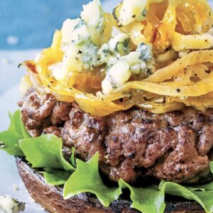A bun-less season Grilled Beef-Chicken Burger paired with Bleu cheese, topped with Crispy Onions