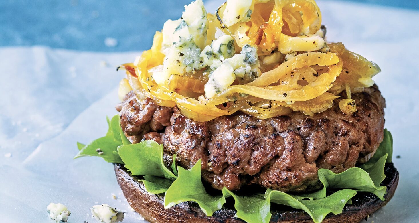 A bun-less season Grilled Beef-Chicken Burger paired with Bleu cheese, topped with Crispy Onions